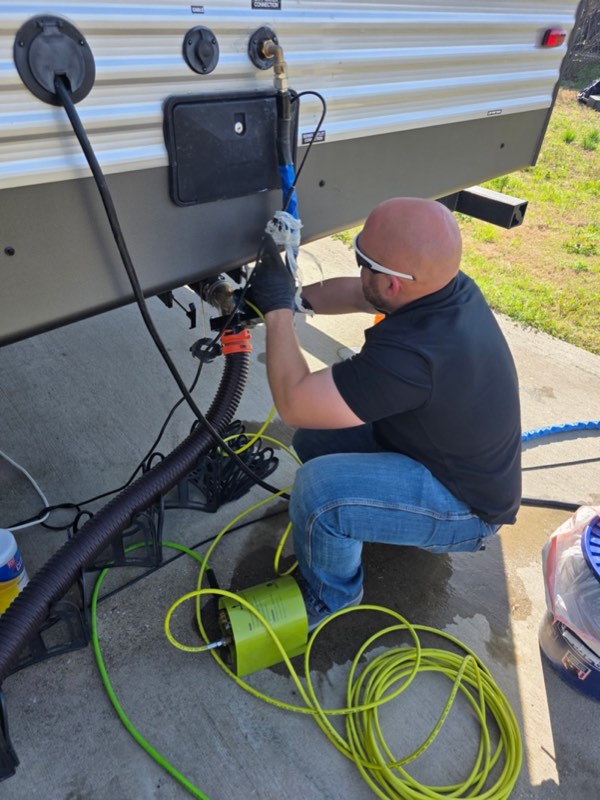 Nick working on RV plumbing connections and holding tank service